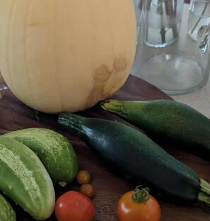Various vegetables resting on a wooden cutting board.